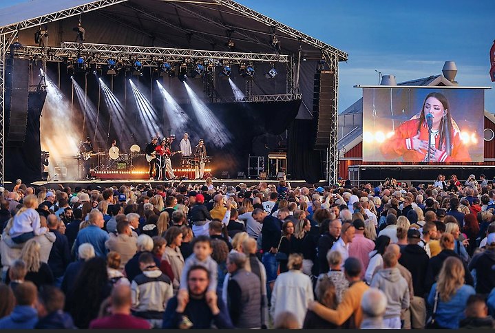 Ett folkhav fraqmför en artistscen på sommarfesten 2022. Foto.